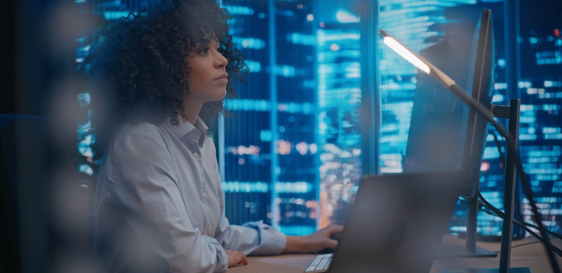 Manager of training sits at desk looking at computer, implementing AI programs.
